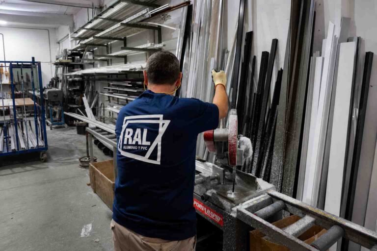 Operario de RAL preparando el corte de perfiles de aluminio durante el proceso de fabricación de una ventana.